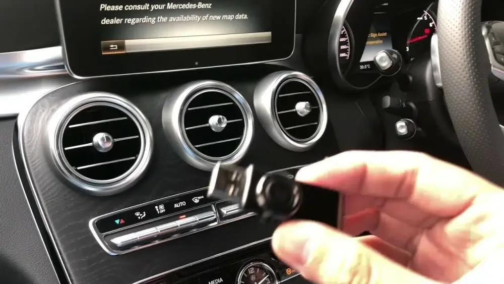 Mercedes-Benz COMAND screen prompting for a navigation map update with a USB stick being inserted into the centre console.